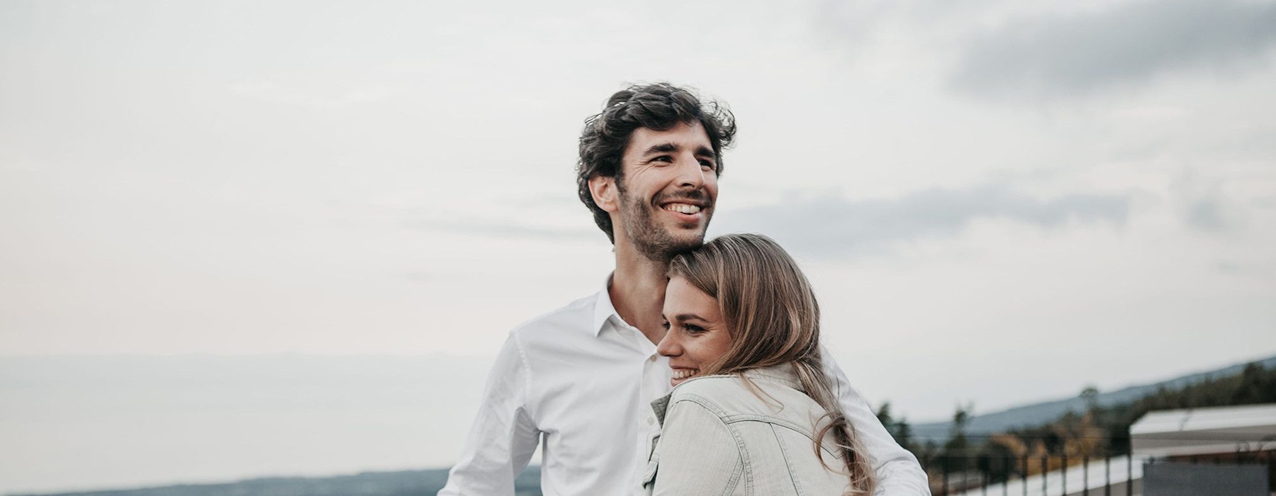 a man and woman hugging on rooftop terrace